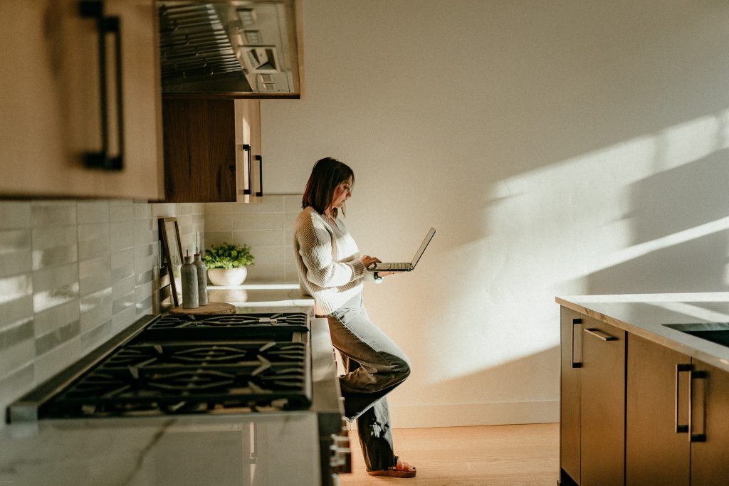 Lacie Pech, Bend Oregon real estate broker, working on her laptop in a Central Oregon kitchen